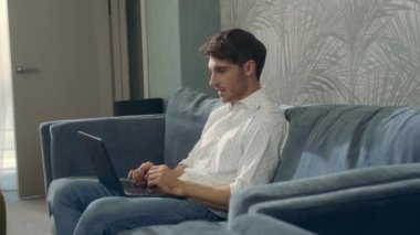 Çekici adam mesaj bilgisayarı alıyor. İçerde dizüstü bilgisayar kullanan gülümseyen adam..