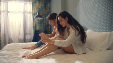 İçeride akıllı telefon kullanan sakin bir çift. Telefon ekranlarına dokunan ciddi bir çift.