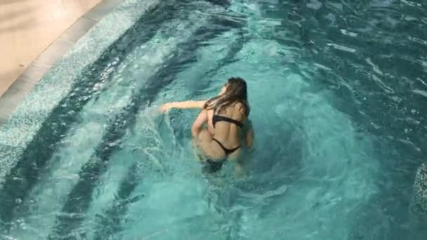 Menina feliz piggyback equitação namorado na piscina. Sorrindo homem carregando menina nas costas — Vídeo de Stock