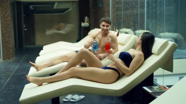 Gelukkig stel dat praat in relax zone. Romantisch koppel drinken cocktails in spa. — Stockvideo
