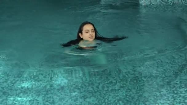 Atractiva mujer nadando en la piscina del spa. Linda chica relajante hidromasaje en el interior. — Vídeos de Stock