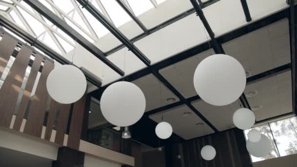 高級ホテルのロビースペース。ガラス天井から吊るされたモダンなシャンデリア. — ストック動画