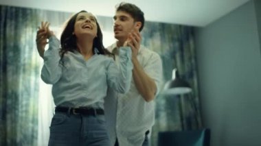 Otelde eğlenen heyecanlı çift. Erkekler yatak odasında kadınlara sürpriz yapıyor..