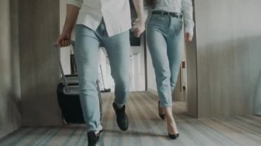 Genç çift bagajlarıyla koridorda ilerliyorlar. El ele tutuşan sevimli bir çift..