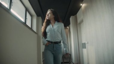 Bavullu küstah kadın koridora çıkıyor. Otele bakan bir kız.