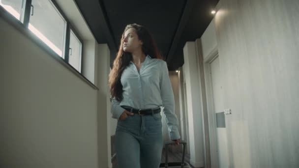 Αλαζονική γυναίκα με βαλίτσα στο διάδρομο. Κορίτσι ψάχνει γύρω στο ξενοδοχείο — Αρχείο Βίντεο