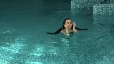Bikini kadın spa havuzunda tatilin tadını çıkarıyor. Güzel kız jakuzide yüzüyor..