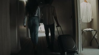 Otel odası arayan romantik bir çift. Genç çift bavulla yürüyor.