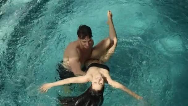 Glückliches Paar, das Spaß im Pool hat. Glücklicher Mann sieht schöne Frau im Spa. — Stockvideo