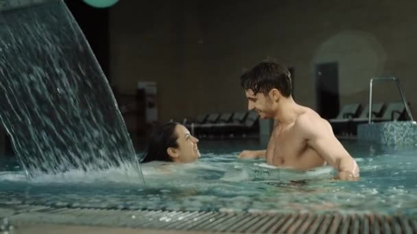 Sinnliches Paar beim Umarmen im Wellness-Pool. Schöne Mann und Frau genießen Urlaub — Stockvideo