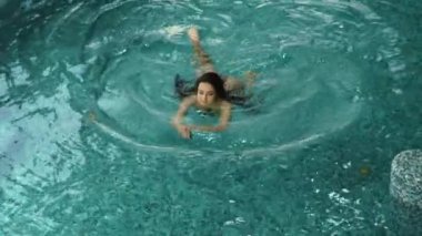 Spa 'da tatilin tadını çıkaran rahat bir kadın. Kapalı havuzda yüzen sevimli kız..