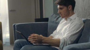 Kızgın adam içeride dizüstü bilgisayara çarpıyor. Otel odasında bilgisayarla çalışan kötü adam..