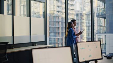 İş adamları cam pencerede şehrin ufuk çizgisiyle iş atamalarını tartışıyor. Tasarımcılar dijital tablet kullanarak inşaat planını gözden geçiriyorlar. Görevde fikir alışverişinde bulunan motive ekip üyeleri.