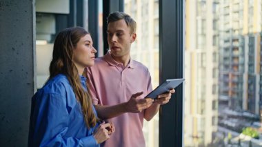 Birkaç meslektaşım panoramik pencerede şirket genişlemesini tartışıyor. Ofis inşaatında konuşan kendine güvenen iki iş ortağı. Tablet bilgisayarı tutan yakışıklı patron. 