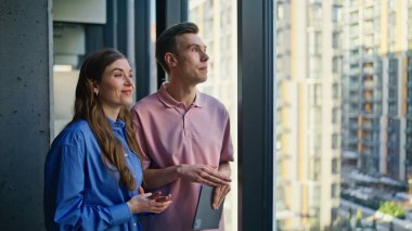 İş ortakları panoramik kabinede tablet planlama şirketinin büyümesini tartışıyor. Kendine güvenen meslektaşlar, stratejiyi analiz eden fikirleri modern ofis içlerindeki sekmeyle paylaşıyorlar. 