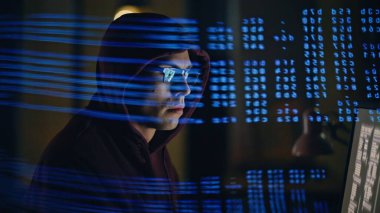 Gece odasındaki şifre kırma sistemi kapanıyor. Siber saldırı programcısı karanlık ışık altında güvenli veri tabanlarını manipüle ediyor. Sahtekar, ekranı uzaktan izleyen algoritmaları sömürüyor