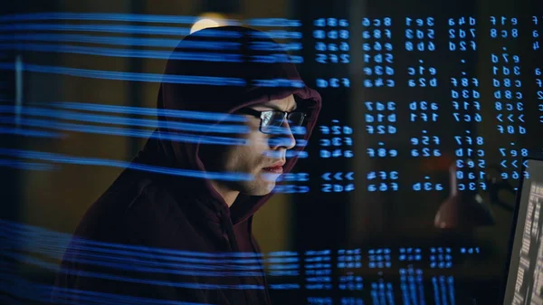 Odaklanmış yazılım geliştiricisi gece geç saatlere kadar tek başına bilgisayar başında çalışıyor. Yüze yansıtılan ve akşam yansıtılan program kodu. Artırılmış gerçeklik makinesi veri ai kavramı öğreniyor 