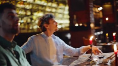 Romantik insanlar, sıcak kafe atmosferinde mum ışığında görücü usulü buluşuyorlar. Gülümseyen erkek kadınlar karanlık restoranda buluşuyor. Mutlu genç arkadaşlar gece takılırken tanışıyorlar. İlişki kavramı.