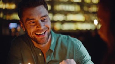 Mutlu ortaklar sıcak, karanlık kafeteryada buluşuyorlar. Romantik akşam buluşmasında gülümseyen adam, kadının elini tutuyor. Neşeli erkek arkadaş, kız arkadaşıyla rahat ve samimi anlar yaşıyor..