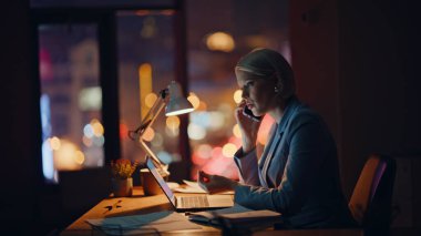 Geç saatlere kadar çalışan kadın yöneticiyi arayıp gece acentesinde not defteri çeviriyorsun. Yorgun bir iş kadınının karanlık iş yerinde son teslim tarihi hakkında konuşması. Evde tek başına bilgisayar başında çalışmaktan yorulmuş.