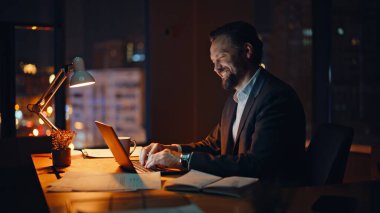 Geç saatte çalışan biri, akşam iş yerinde el sallayarak bilgisayarın web kamerasına el sallamaya başlar. Gülümseyen adam başlangıç projesi detaylarını online toplantıda tartışıyor. Sanal konferansta profesyonel danışman konuşuyor 