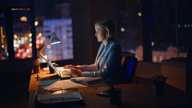 Akşam çalışma alanında bilgisayarı daktilo eden çalışkan bir kadın. Ciddi bir iş kadını geç saatlere kadar çalışıyor bilgisayarla ofisteki akıllı telefonu arıyor. Akıllı serbest yazar geceleri tek başına online proje yaratıyor 