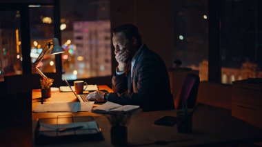 Esneme direktörü karanlık çalışma alanında dizüstü bilgisayarı daktilo ediyor. Geç saatlere kadar çalışan işadamı kontrat belgelerini kontrol etmekten yoruldu. Yorgun düşmüş ofis müdürü gece tek başına çok çalışıyor.