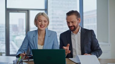 Dost canlısı uzmanlar şehir merkezindeki çalışma alanında bilgisayarla sanal toplantı yapıyorlar. Mutlu iş kadını işadamı kabinede iyi bir anlaşma yapıyor. İş ortakları video çağrısı