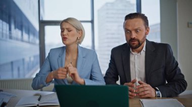 Stresli iş ortakları büyük kabinede dizüstü bilgisayarda çalışıyor. Hüsrana uğramış patron iş yerindeki bilgisayarı kapatan sekreter kadını fırlatıyor. İki ezik ofiste gergin bir şekilde karar veriyor. 