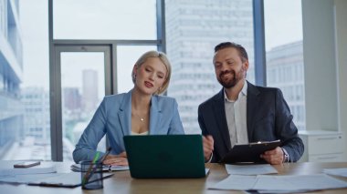 İş arkadaşlarının panoramik iş yerinde çekilmiş videoları. İş arkadaşları sanal toplantıda, hafif ofisteki laptop web kamerasına işaret ederek konuşuyor. Ortaklar çevrimiçi dostça sohbetin keyfini çıkarıyorlar 