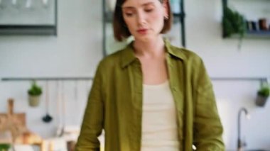 Kadın elleri salatayı doğrama tahtası üzerinde kesiyor. Mutfağı yakın plan. Kız elleri taze yeşillikleri bıçaklı yemek pişirme ile kesiyor. Yemek meraklısı vejetaryen yemeği için sağlıklı vitamin malzemeleri hazırlıyor. 