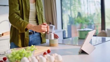 Bayan şef, tablete dokunuyor. Sabah televizyon programı seyrediyor. Mutfağa taze kahve koyuyor. Tezgahta duran kız akıllı bir aletle salata pişiriyor. Esmer kadın elinde fincanla saçlarına dokunuyor.