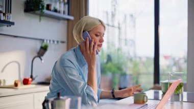 Bilgisayarda oturan iş kadınını iş meselelerini çözerken aramak. Gülümseyen serbest çalışan kadın elinde kahve fincanıyla cep telefonuyla konuşuyor. Mutlu çevrimiçi yönetici kapalı alanda akıllı telefon sipariş alıyor 