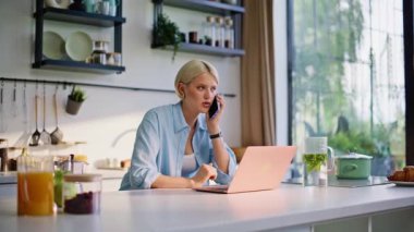Neşeli internet yöneticisi cep telefonunu arıyor. Ev ofisini kapatıyor. Mutfakta elinde kahve fincanı tutan pozitif bir iş kadını. Kadın serbest çalışan telefonda müşteri konuşuyor. 
