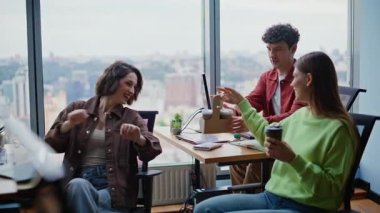 Şirket odasındaki meslektaşlarına kahve getiren gülümseyen kadın. Neşeli grup çalışanları tatillerini modern ofiste sıcak içecekleri paylaşarak geçiriyorlar. İçerde çay yudumlayan mutlu iş arkadaşları. 