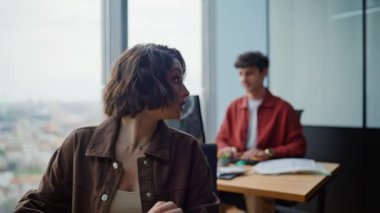 Aktif iş arkadaşları, modern ofis açık alanlarında birlikte çalışma projesini tartışıyorlar. İş yerinde kağıtları geçen iyi yöneticiler. Lider kadın gülen adama bilgiyi açıklıyor.