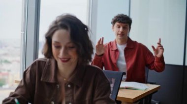 Panoramik kabinede iletişim kuran iki öğrenci. Gülen insanlar başarılı takım çalışmalarından hoşlanırlar açık alanda el çırpmaktan. Tasasız gençler iş birliği yaparak eğleniyorlar.