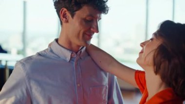 Sevgi dolu çift evde dans edip romantik vakit geçiriyorlar. Yakın çekim. Mutlu sevgili panoramik dairede dans ederken sevgilisine sarılıyor. Sevecen bir çift, aşkın tadını çıkarıyor, köpüklü şarap içiyor.