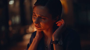 Karanlık ofis kapanışında boyuna masaj yapan fazla mesai uzmanı. Portre gerilmiş iş kadını geç saatlerde kas ağrısından muzdarip. Çok çalışan gece vardiyası müdürü gerginlik hissediyor. Profesyonel tükeniş.