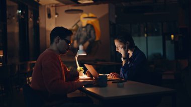 İki programcı karanlık işyerinde fazla mesai yapmaktan yoruldu. Yorgun işçiler bilişim şirketinin ofisinde kodlamayı gece geç saatlerde bitiriyor. Lambada oturup konuşan çok çalışan meslektaşlar. Profesyonel tükeniş.