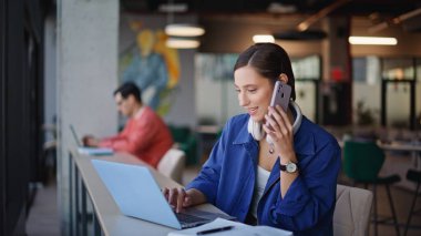 Başarılı bir yönetici, kafenin kapanış masasında not defterine akıllı telefonlardan notlar yazarak konuşuyor. Gülümseyen iş kadını dizüstü bilgisayarı arıyor. Havalı kadın kafeteryada cep telefonuyla uzaktan kumandayı tartışıyor.