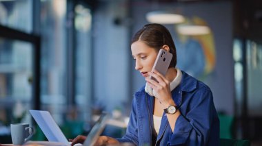 Şirket temsilcileri modern ofis iş yerindeki telefonları yakın çekimde konuşuyorlar. Gülümseyen kadın yöneticiler müşterilere cep telefonuyla yardım ediyor. Profesyonel çalışanlar akıllı telefondan müşterilerine danışıyor..