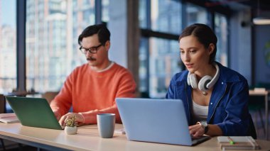 Arkadaş canlısı ekip modern ofisin açık alandaki görevini tartışıyor. Dizüstü bilgisayarlarla iş birliği yapan gülümseyen kadın. Bıyıklı yönetici kahve içiyor. İş yerinde çalışan bir kadınla konuşuyor.