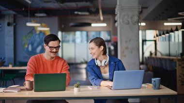 Üretken iş arkadaşları, ortak iş yerinde beş tane yakın çekim yaparak yeni bir başlangıç yaratıyor. Gülümseyen meslektaşlar iş sonuçlarını dizüstü bilgisayarlarla paylaşıyorlar. Pozitif takım arkadaşları birlikte etkin bir takım çalışmasının keyfini çıkarıyorlar..