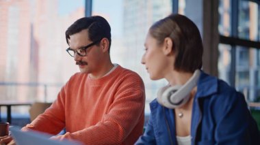 İki acemi pazarlama ajansının iş yerinde konuşuyor. İş yerinde dizüstü bilgisayarlarla proje stratejisini tartışan gülümseyen meslektaşlar. Dost canlısı yöneticiler birlikte yatırım kampanyası planlıyor