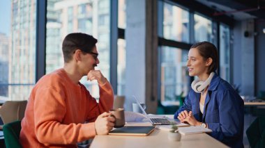 Olumlu iş arkadaşları yaratıcı ajansların yakın planlarında iletişimden hoşlanırlar. Gülümseyen meslektaşlar ofiste iş fikirlerini tartışıyorlar. Arkadaş canlısı ekip iş yerinde dizüstü bilgisayarla haberleri paylaşıyor.