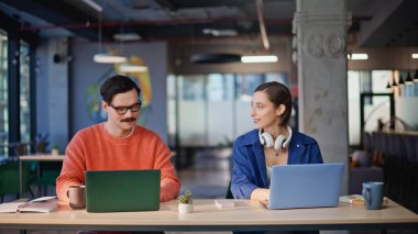 İş yerindeki gülümseyen iş arkadaşları yaratıcı ajans yakın çekim. İş yerinde tokalaşan iki acemi. Dost canlısı çalışanlar proje üzerinde verimli bir ortaklık kurmaya başladılar