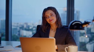 Akşam ofisindeki dizüstü bilgisayara bakan yaratıcı işçi pazarlama stratejisini yakından düşünüyor. Gülümseyen kadın yönetici geç saatlere kadar çalışıp kariyer geliştirmeyi düşünüyor. Bilgisayarda e-posta yazan zarif bir iş kadını.