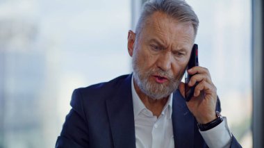 Sinirli direktör cep telefonuyla konuşuyor. Akıllı telefondan bağıran duygusal kıdemli yönetici iş başarısızlığından dolayı stresli. Öfkeli yönetici şirket iflası için endişeli çağrı yaptı..