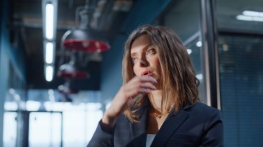 Ofis lobisinde kafası birbirine değen endişeli bir çalışan akıllı telefonu kapalı tutuyor. Stresli iş kadını koridorda iş problemleri düşünüyor. Endişeli kadın yönetici iş sorunları çözümleri arıyor.